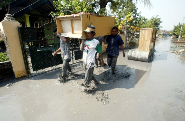 Indonesian villagers carry their belongings in Sidoarjo, East Java