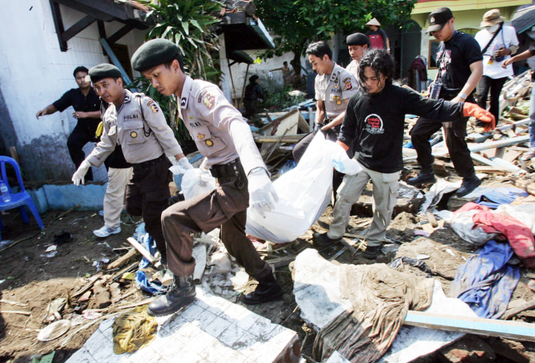 Rescuers carry the body of a tsunami victim in Pangandaran, Indonesia, on Wednesday. Jittery residents fled the resort town hardest-hit by Monday's tsunami amid unfounded rumors another killer wave was about to hit.
