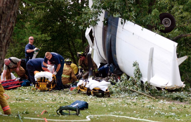 Rescue workers try and aid victims of a small plane crash on Saturday in Sullivan, Mo.
