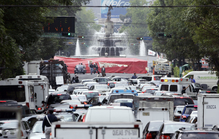 Buses and cars move slowly along the streets Monday in Mexico City. Supporters of the country's leftist presidential candidate paralyzed the city's financial district and refused to leave.