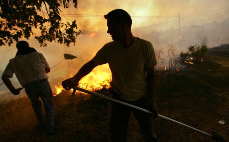 Villagers try to extinguish a fire in th