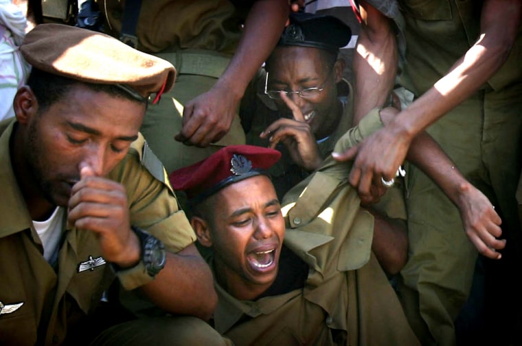 Relatives and friends of Staff Sgt. Moshe Malko Ambao cry during his funeral at the military cemetery in the city of Lod, Israel, on Tuesday. 