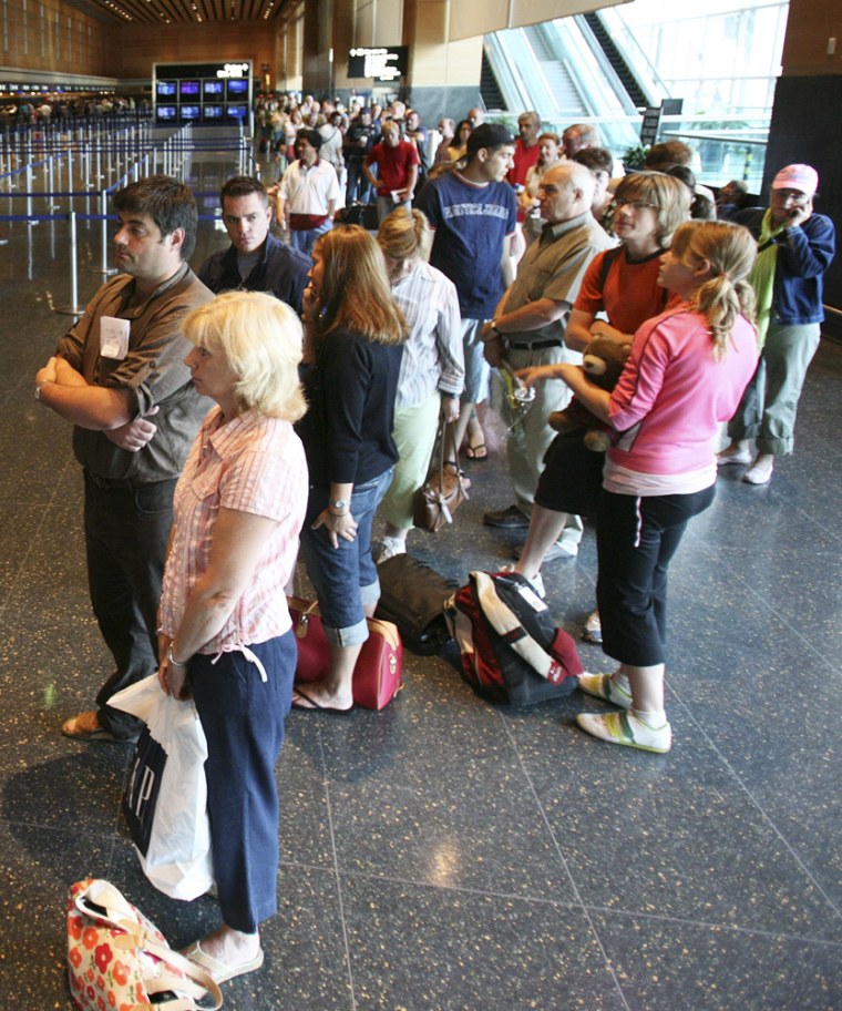 Departing passengers wait in a line that stretches the length of the international terminal to pass through security at Logan International Airport in Boston, Thursday, Aug. 10, 2006. (AP Photo/Michael Dwyer)