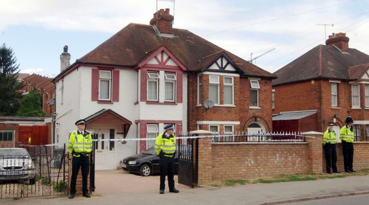 Police officers stand outside a house in High Wycombe, England, Thursday after a raid connected with a terrorist plot to blow up jetliners in mid-air.