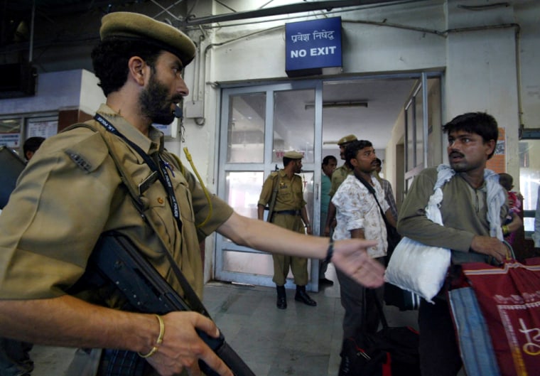 A security officer stops a man to check his luggage at the main entrance of the railway station on Friday in Jammu, India. 