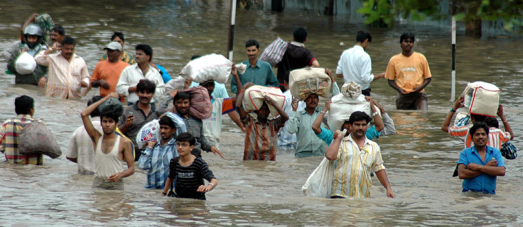 People wade along a flooded street in Surat, in the western Indian state of Gujarat, India, on Friday.