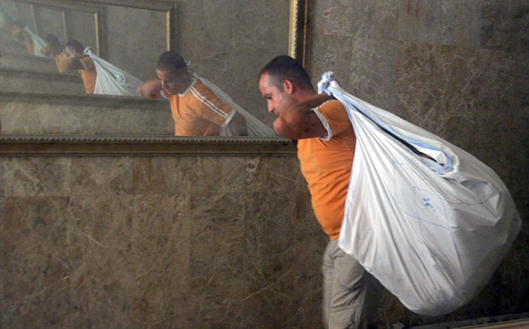 A Lebanese man evacuates some of his belongings from his house in a Hezbollah stronghold in Beirut, Lebanon, Saturday, Aug. 12, 2006, after the area was targeted by Israeli airstrikes. Israeli warplanes struck several targets in north, east and south Lebanon early Saturday, killing at least two people and wounding several others. The attacks came just hours after the U.N. Security Council adopted a resolution calling for an end to the war between Israel and Hezbollah. (AP Photo/Sergey Ponomarev)