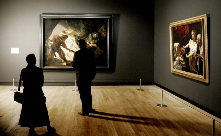 Two people look at paintings 22 February