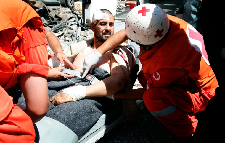 The Red Cross evacuates an injured fighter on Monday in the southern Lebanese town of Khiam.