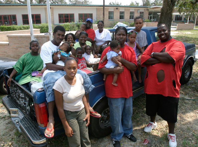 Andre Dunn, right, and members of his extended family pose around the pickup truck that carried them to safety in September 2005 at a Red Cross shelter in Pearl River, La. John Russell, who was slain in New Orleans in late July, is seated on the truck, second from left, with his daughter in his arms.