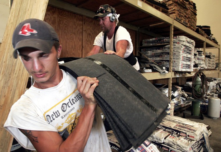 Brandt Stockstill from Marrero, La., carries shingles at Robertson Roofing and Siding in Belle Chasse, La., on Thursday, Aug. 17, 2006. Roofers ads in the new yellow pages phone book have increased with the demand for the work to repair the damage of Hurricane Katrina. (AP Photo/Alex Brandon)