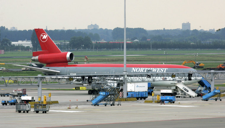 The Northwest Airlines flight to Bombay that was escorted back to Amsterdam's Schiphol Airport after the crew reported some passengers were behaving suspiciously sits on the airport tarmac on Wednesday.