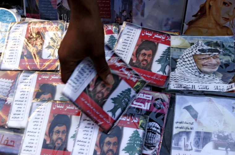 ** FILE ** A Palestinian vendor sells CDs of popular songs performed by Palestinian singers, including the \"Hawk of Lebanon\" by the Northern Band, that praises Hezbollah leader Sheik Hassan Nasrallah, whose photo appears on the cover,  in the West Bank city of Ramallah in this Aug. 8, 2006 file photo. At the height of the Israel-Hezbollah war, the Northern Band wrote new lyrics, in praise of Nasrallah, for an old tune. The \"Hawk of Lebanon\" song tapped into Nasrallah's huge popularity among Palestinians and became an instant hit.(AP Photo/Nasser Shiyoukhi, File)
