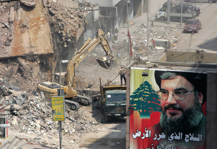 Poster of Hizbollah leader Sayyed Hassan Nasrallah is hung near rubble of damaged building in Beirut's southern suburbs