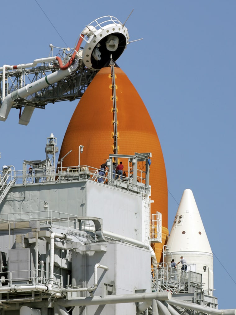 NASA workers gather near the top of the shuttle Atlantis' external fuel tank on Launch Pad 39B at Kennedy Space Center in Florida on Monday, in preparation for Wednesday's launch attempt.