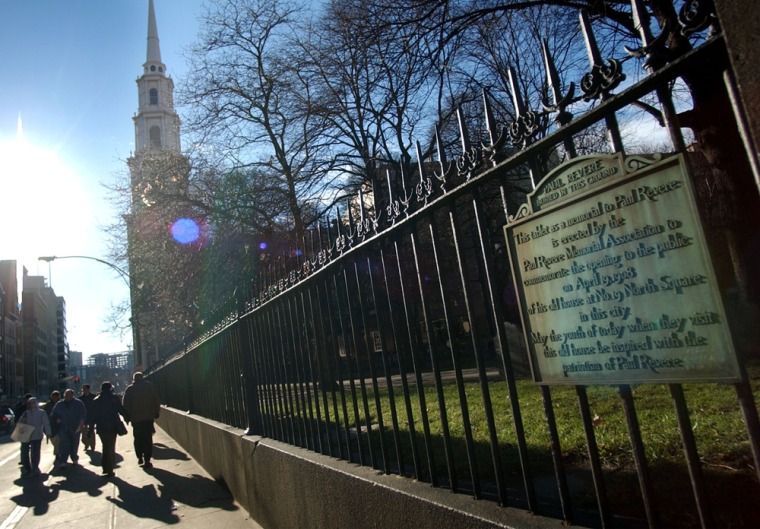A marker, part of which reads "Paul Revere buried in this ground," is seen on the fence at the Old Granary Burying Ground in Boston.