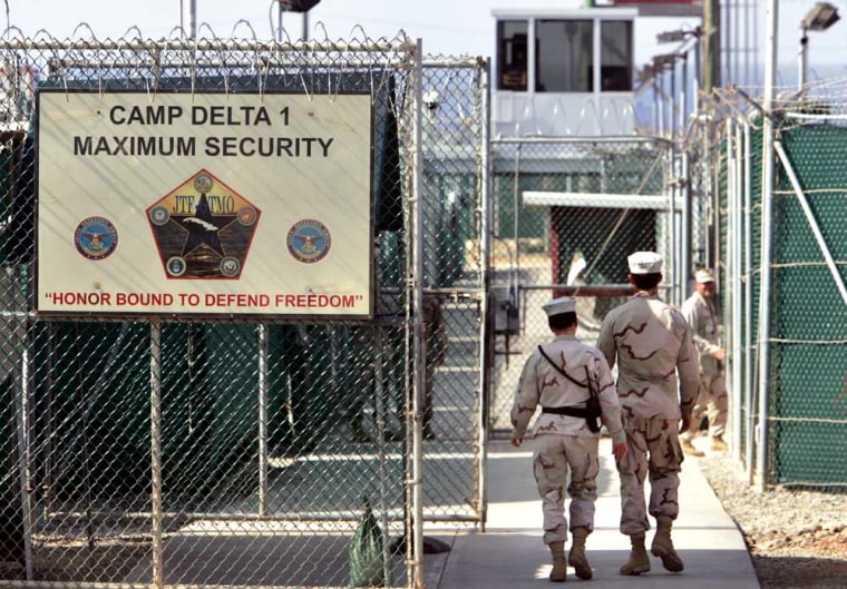 In this photo, reviewed by a US Department of Defense official, U.S. military guards walk within Camp Delta military-run prison, at the Guantanamo Bay U.S. Naval Base, Cuba on Tuesday, June 27, 2006. The Supreme Court ruled Thursday that President George W. Bush overstepped his authority in creating military war crimes trials for Guantanamo Bay detainees, a rebuke to the administration and its aggressive anti-terror policies.