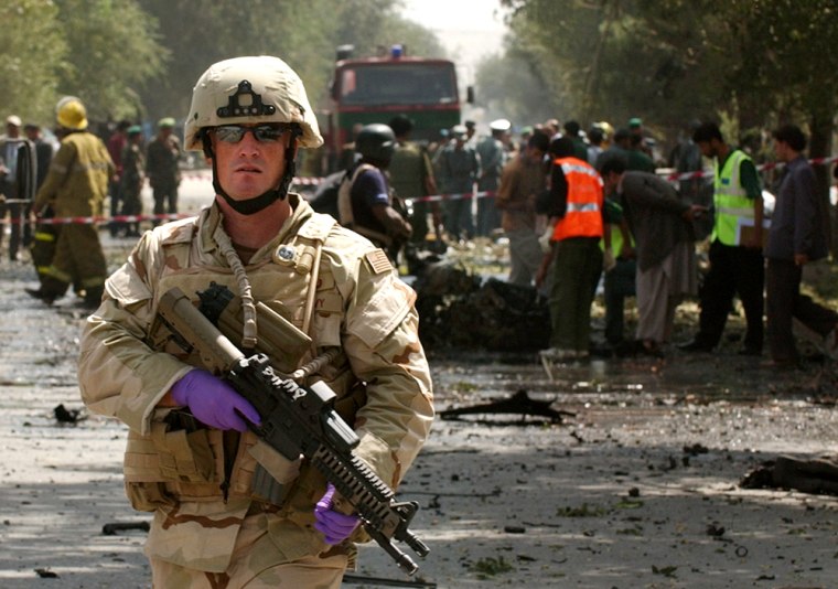 A U.S soldier stands guard at the bomb blast site near the U.S. Embassy in Kabul, Afghanistan, on Friday. A massive car bomb struck a convoy of U.S. military vehicles, killing at least 10 people, including two American soldiers.