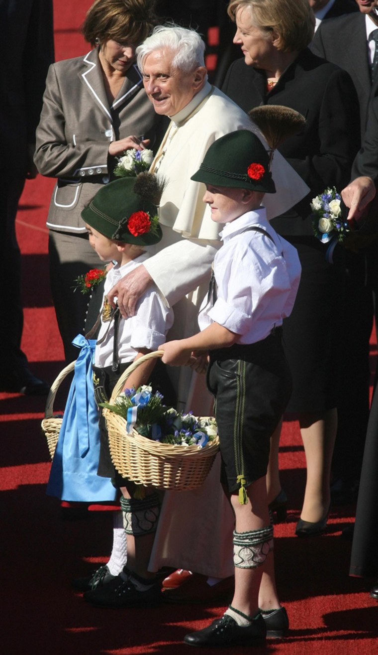 Pope Benedict XVI is welcomed by children in traditional Bavarian clothes after his arrival at Munich's international airport
