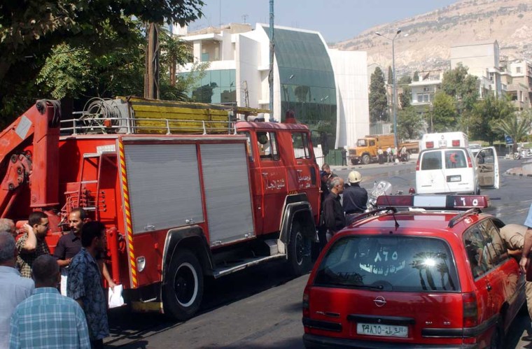 Syrian security forces and firefighters are seen in front of the US embassy in Damascus on Tuesday, Sept. 12, 2006. Syrian security forces killed three attackers, the government said, after gunmen apparently blew up a car outside the U.S. Embassy and exchanged fire with Syrian guards on Tuesday in a bold attack on Damascus' diplomatic neighborhood.