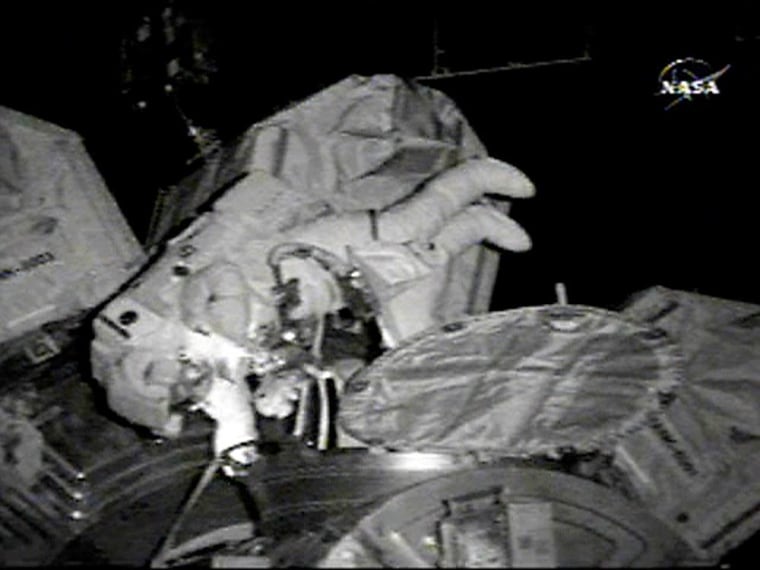 Astronaut Joe Tanner emerges from the airlock at the beginning of his spacewalk with astronaut Heidemarie Stefanyshyn-Piper as they begin installing an addition to the space station.