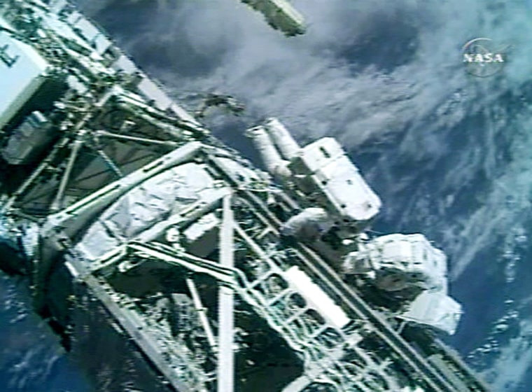Canadian Space Agency astronaut Steven MacLean and fellow spacewalker Dan Burbank stow their gear near the end of their extravehicular excursion