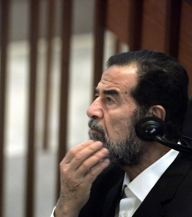 Former Iraqi President Saddam Hussein listens to a defence testimony as his trial on genocide charges resumes for the third day at the fortified Green Zone in Baghdad