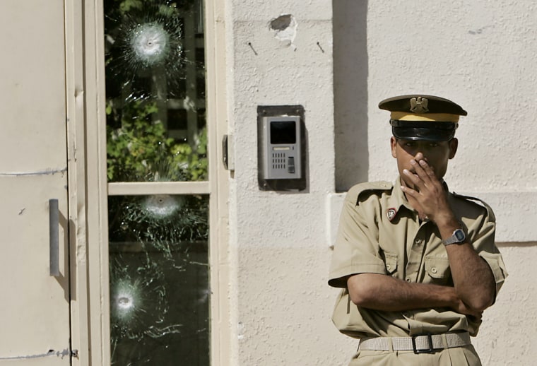 A Syrian policeman stands in front of the VIP visitors' entrance to the U.S. Embassy which is marked by bullets, in Damascus, Syria, on Tuesday, after armed Islamic militants attempted to storm the building. 