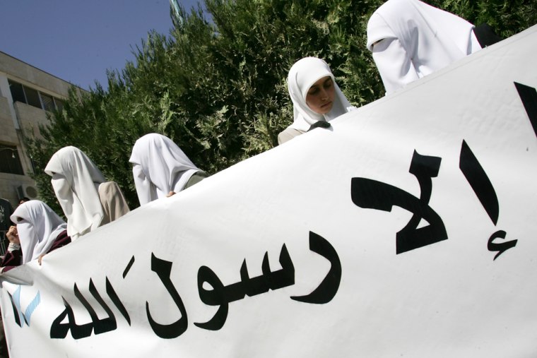 Veiled Muslim women hold a poster during a Monday protest against Pope Benedict XVI's recent remarks about Islam, in Amman, Jordan.
