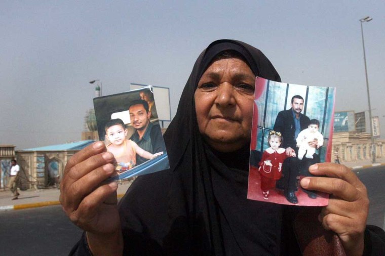 A woman shows off photographs of her missing sons to a rights organization in Baghdad in August.