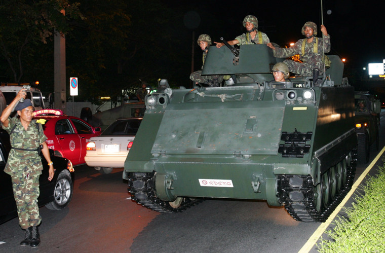 Thai soldiers ride in a tank next to the government headquarters in Bangkok on Tuesday.