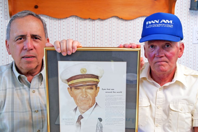 Former Pan Am employees Anthony J. La Pera, left, and Richard Vieta, hold a Norman Rockwell Pan Am advertisement in Lapera's home in West Babylon. The two are among 15,000 workers to paid for leftover wages and accrued vacation 15 years after the airline shut down.