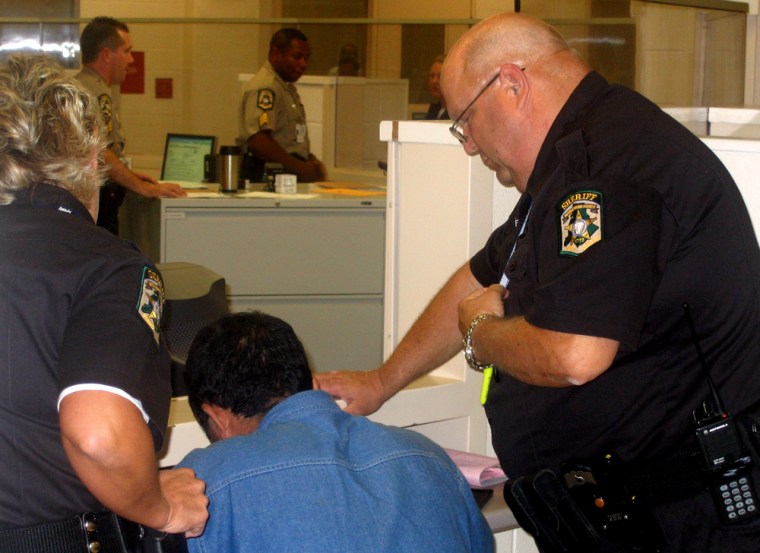 Illegal immigrants being processed by Mecklenburg County sheriff's department officers.  