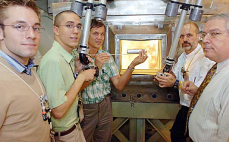 MIT researchers test-fit a prototype nuclear fuel capsule using the manipulators of a hot box at MIT's Research Reactor. From left, the researchers are Tyler Ellis, David Carpenter, Pavel Hejzlar, Gordon Kohse and Mujid Kazimi.