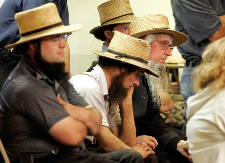 A group of Amish men react as Cmdr Miller comments on the shooting at the Georgetown school near Lancaster, Pennsylvania