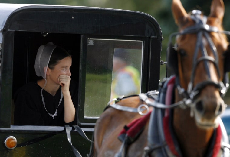 An Amish woman looks out from her wagon at the scene of the Georgetown school shooting in Nickel Mines near Lancaster, Pennsylvania