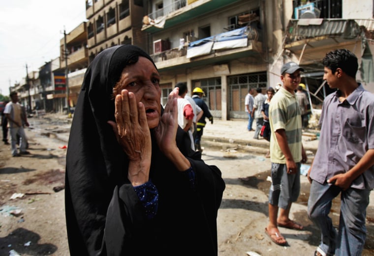 An Iraqi woman reacts at the site where