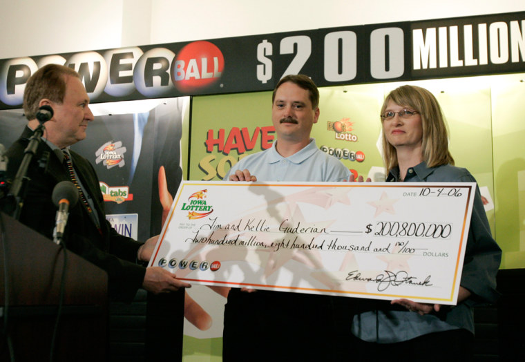 Tim and Kellie Guderian, of Fort Dodge, Iowa, receive a check from Iowa Lottery CEO Edward Stanek, left, on Wednesday. Tim served during Desert Storm; Kelly works at Wal-Mart.