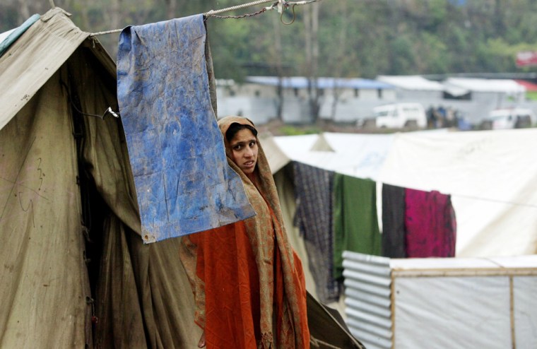 A woman who survived the October 8, 2006, earthquake stands outside her tent in the devastated city of Muzaffarabad