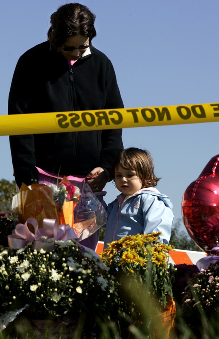 Evelyn Poulos and her 2-year-old daughter Mary Poulos from Newark, Del., visit a makeshift memorial on the corner of Mine Rd. and White Oak Rd. in Nickel Mines, Pa., Sunday., Oct. 8, 2006 for the girls slain in Monday's Amish school shooting just down the road. Charles Carl Roberts IV  stormed the Amish schoolhouse killing five girls and wounding five others  before turning the gun on himself.   (AP Photo/Carolyn Kaster)