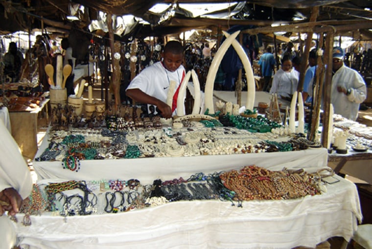 Polished, unworked elephant tusks, as well as carved products, are seen for sale in Benfica, Angola. 