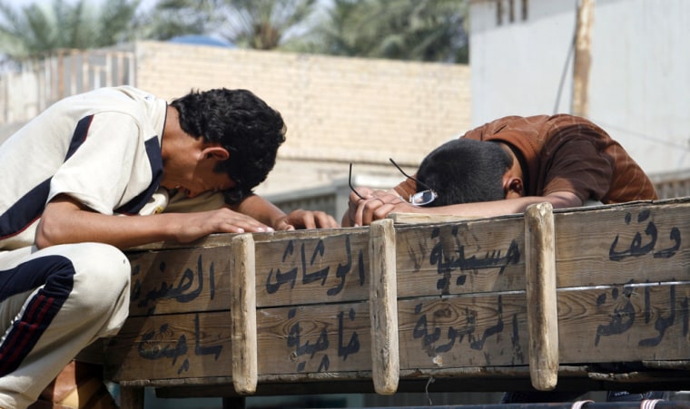 Relatives cry over a coffin outside a hospital morgue in Baghdad