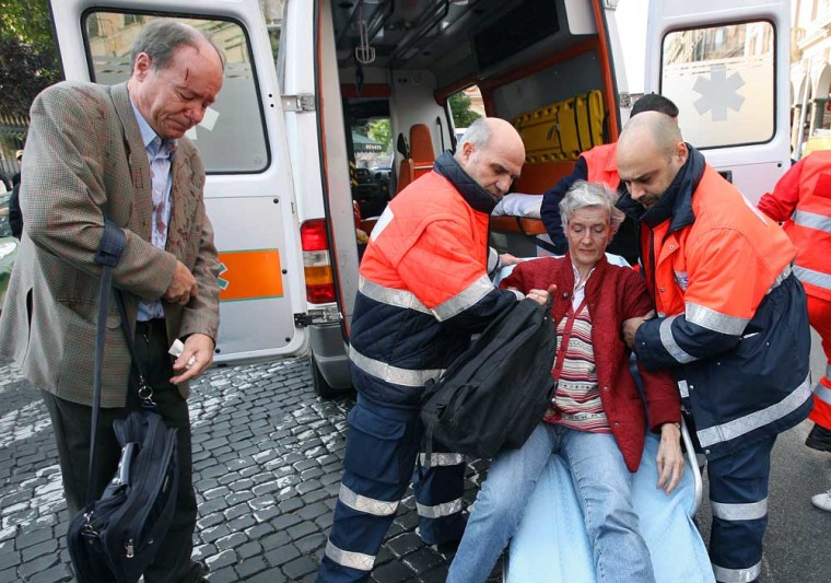 An injured woman is carried into an ambulance by a rescue team after two metro trains collided near the Victor Emmanuele II station in Rome on Tuesday.