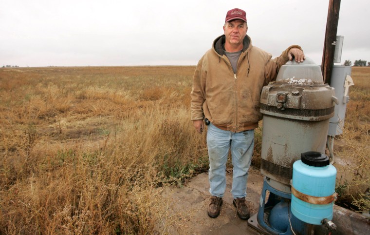 Farmer Gary Weibert of Wiggins, Colo., stands by a water pump he was ordered to disconnect, an order affecting 440 wells across the region.