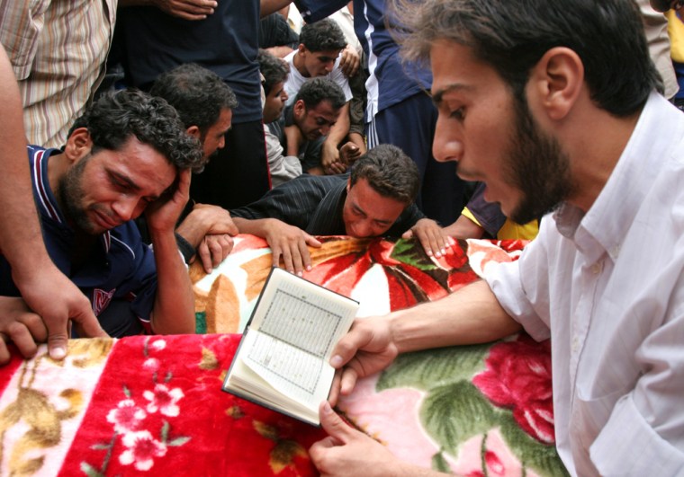 Relatives pray over coffins of four men killed in joint U.S. and Iraqi forces raid  in Baghdad's Shiite enclave of Sadr City Wednesday Oct. 25, 2006. The men were killed in a U.S. airstrike during a raid by US and Iraqi forces to capture a top illegal armed group commander directing widespread death squad activity throughout eastern Baghdad, the U.S. military said in a statement. (AP Photo/Karim Kadim)