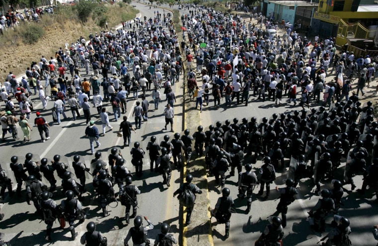 Mexican federal police push back protesters as they enter Oaxaca on Sunday.
