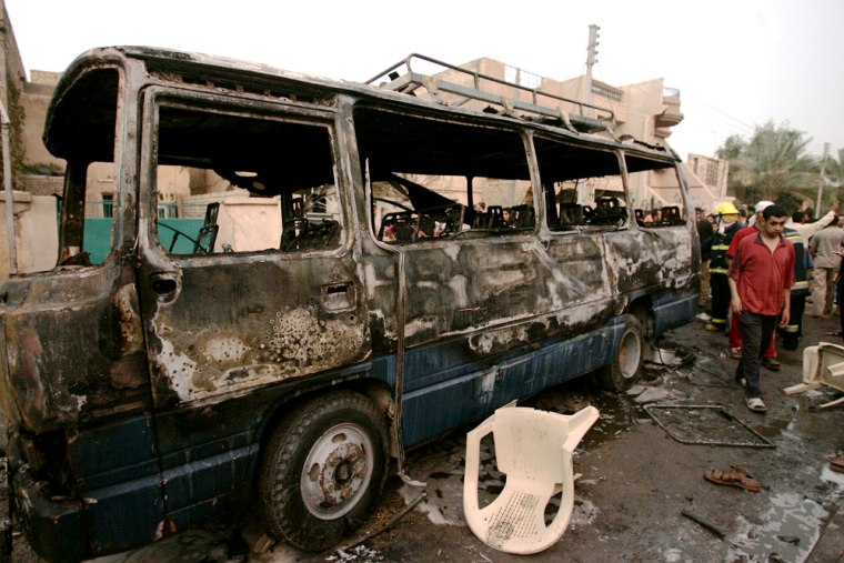 A burnt bus lies on a road after a car bomb attack that targeted a Shi'ite wedding procession in Baghdad