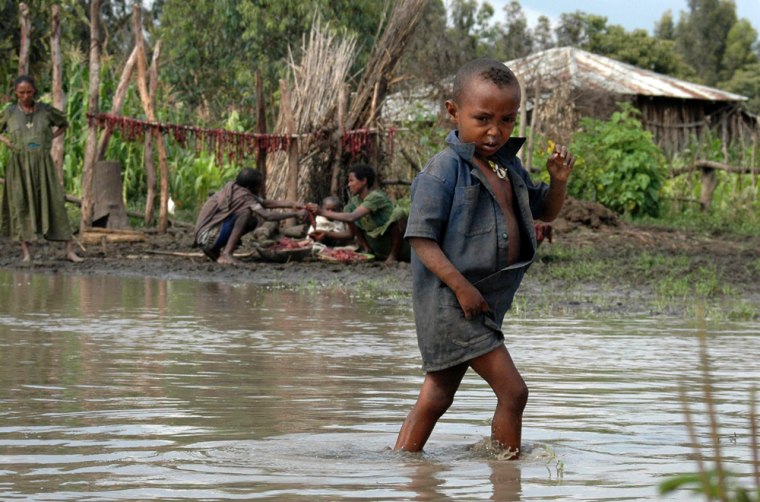 A boy wades through floodwater in the village of Abiabo