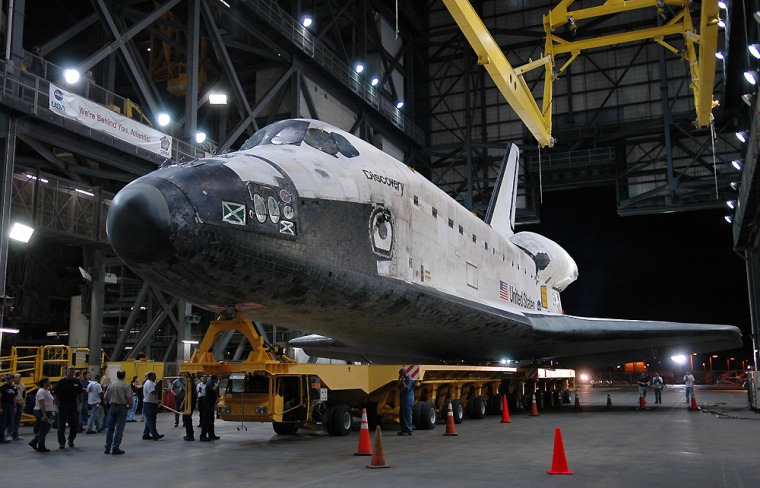 The Space Shuttle Discovery, shown inside the vehicle assembly building at Kennedy Space Center at Cape Canaveral, Fla., will be mated to its large external tank and twin solid rocket boosters already stacked on the mobile launcher platform.