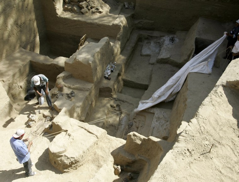 Peruvian workers clean graves containing a trove of pre-Inca artifacts in Ferrenafe, Peru, Tuesday, Nov. 21, 2006. Archaeologists in northern Peru said Tuesday they have unearthed 22 artifact-rich graves containing a trove of pre-Inca artifacts, including the first \"tumi\" ceremonial knives ever excavated scientifically. The more than 900-year-old tombs were found next to a pyramid in the Pomac Forest Historical Sanctuary, about 680 kilometers (420 miles) northwest of the capital, Lima. They are from the Sican culture, which flourished on Peru's northern desert coast from A.D. 750 to 1375. (AP Photo/Martin Mejia)